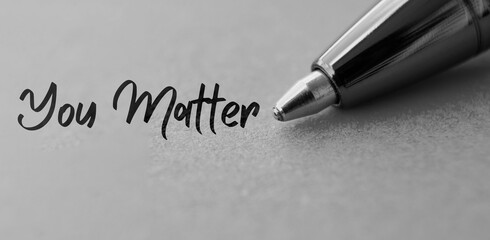 You matter text with closeup pen background in black and white