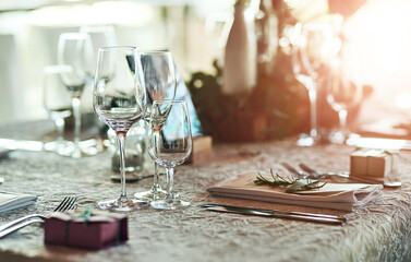 Wedding, table and glasses for occasion arrangement, celebration and fine dining with place setting. Party favour, catering and theme decoration for social gathering, reception and elegant lunch
