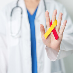 World hepatitis day awareness month, 28 July. Doctor holding Red and Yellow ribbon. Liver cancer,...