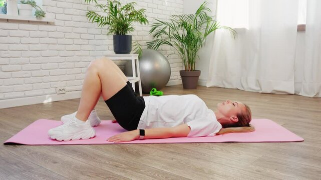 Woman Doing Glute Bridge Exercise on Pink Mat in Home Gym