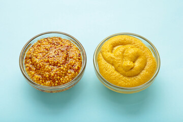Dijon mustard with french mustard on blue background.