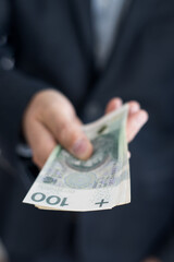 Osoba trzymająca w dłoni banknoty pieniężne, Polskie Złote. 