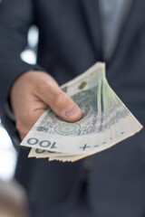 Osoba trzymająca w dłoni banknoty pieniężne, Polskie Złote. 