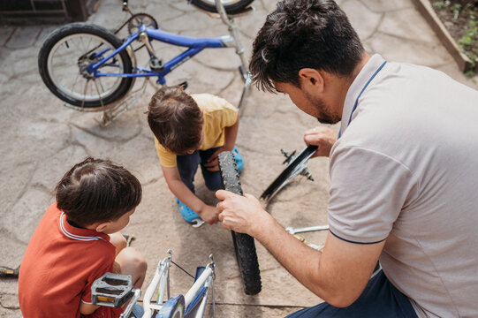 Father and sons repairing bicycle