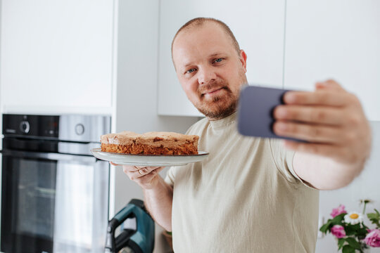 Man showing cake on video call through smart phone at home
