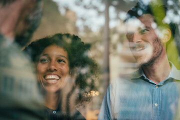 Smiling business professionals sharing ideas with coworkers