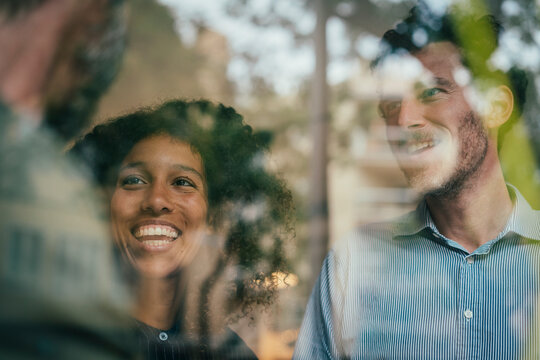 Smiling business professionals sharing ideas with coworkers