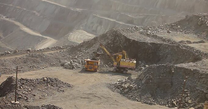 Quarry truck driving on the road in deep quarry. A large mining truck transports ore. Dumper.