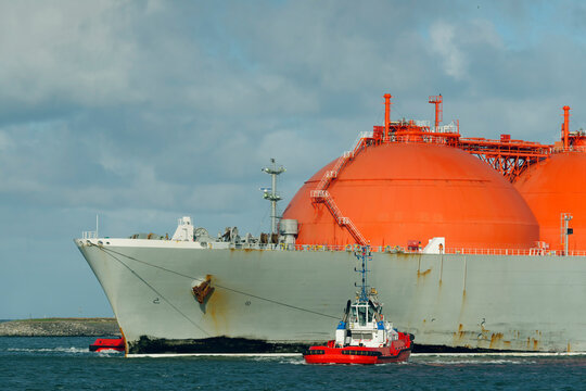 LNG tanker ship arriving at Rotterdam harbor under sky in Netherlands
