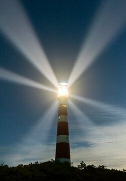 Illuminated lighthouse under sky at dusk