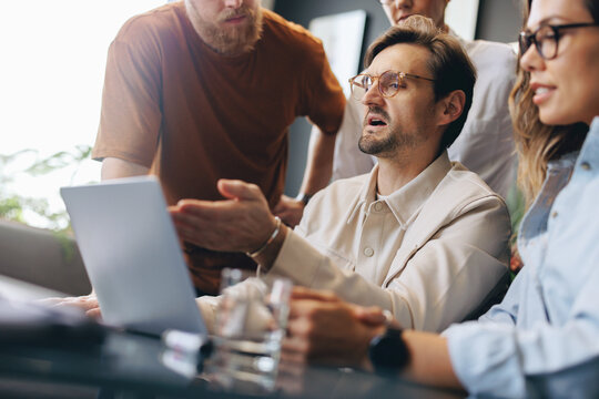 Business man showing his colleagues a slideshow presentation of his ideas on a laptop