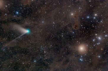 Comet in front of celestial background with Hyades open star cluster