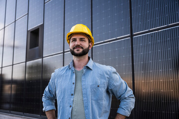 Contemplative engineer wearing denim shirt in front of solar panels