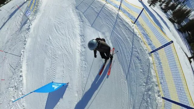 Top shot following a man skiing on a ski slope during a sunny day in the austrian Alps
