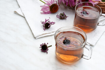 Echinacea purpurea. Fresh herb. Cup of herbal echinacea and dry tea on a light table. Side view. Copy space.
