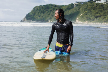 portrait of latin surfer man rides the tropical waves in Mexico Latin America, hispanic people...