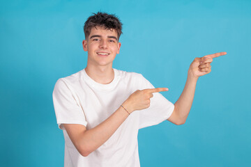 isolated young man pointing on color background