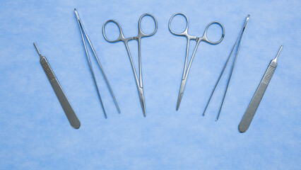 Staindless surgical instruments used in surgery are placed on a blue background. Medical equipment used in surgery. Surgical instruments. Medical equipment.