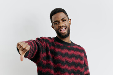 Fototapeta premium Confident man in red and black sweater pointing directly at camera on white background