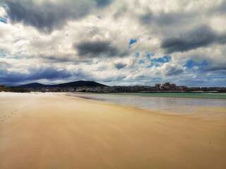the beach of San Cosme de Barreiros, deserted, in the month of June, Lugo, Galicia, Spain, in the background the town of Foz,