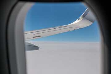 Clouds and sky as seen through window of an aircraft.