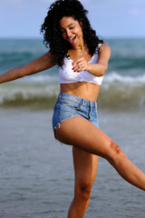 attractive woman dressed and walking along the beach shore