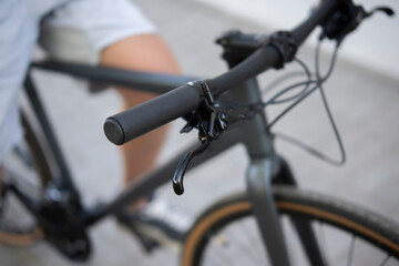 hand grips the handlebars of a bicycle with hydraulic brakes, as the rider prepares to cycle on a...