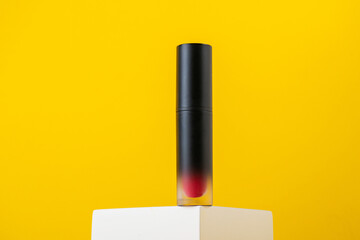 Close up of lip gloss with stylish props on yellow background.