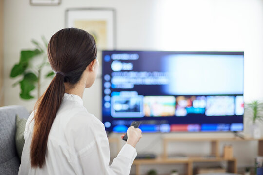リビングにて動画配信サービスを楽しむ日本人女性