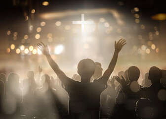 Christians raising their hands in praise and worship at a night music concert
