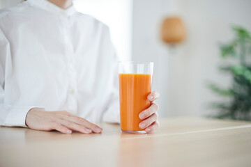 リビングにて朝食の野菜ジュースを飲む日本人女性