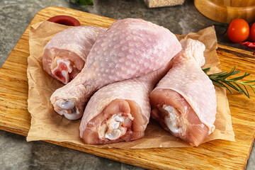 Raw uncooked chicken drumsticks over board