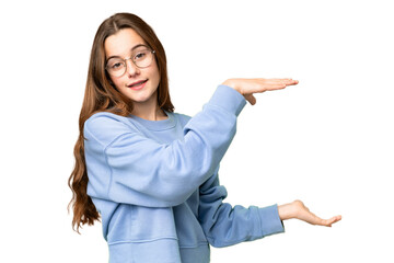 Teenager girl over isolated chroma key background holding copyspace to insert an ad