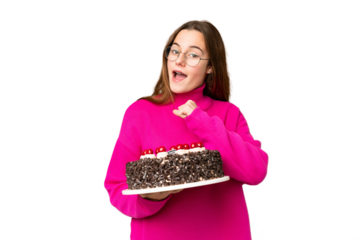 Teenager girl holding birthday cake over isolated chroma key background celebrating a victory