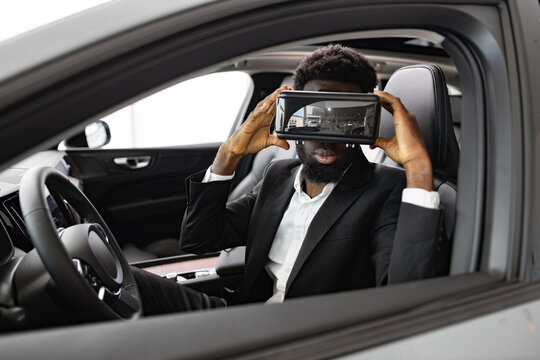 Exploration of modern technology in automotive industry. Businessman watches presentation of interior of new car with help of 3D virtual glasses in dealership. - Powered by Adobe