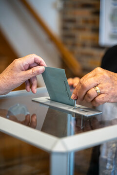 vote en r&eacute;publique fran&ccedil;aise, enveloppe gliss&eacute;e dans une urne transparente et ouverte  avec un clapet par un assesseur