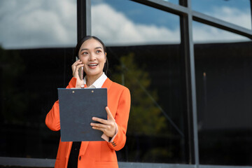 Asian businesswoman involved in cellphone call conversation  giving professional consultation to client or negotiating project.