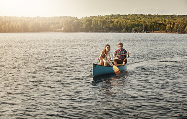 Canoeing, water and couple on lake for travel, vacation or weekend trip with summer adventure. Hobby, bonding and portrait of man and woman row boat together on river for holiday activity in Norway. © ReeseArcurs/peopleimages.com