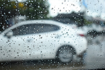 water drop on mirror in defocused car parking background