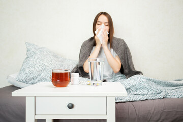 Teenage girl with runny nose, sick in bed with fever, teenager experiencing cold and flu.