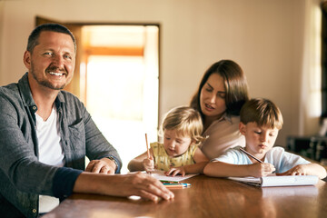 Family, development and homework with children, drawing and notepad with proud parents for learning. Kids, home school or study with siblings, mother and father in kitchen for growth or teaching