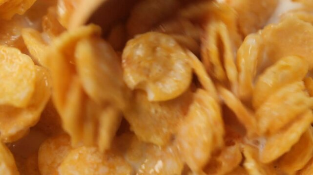 spoon pick corn flakes mixed with milk 