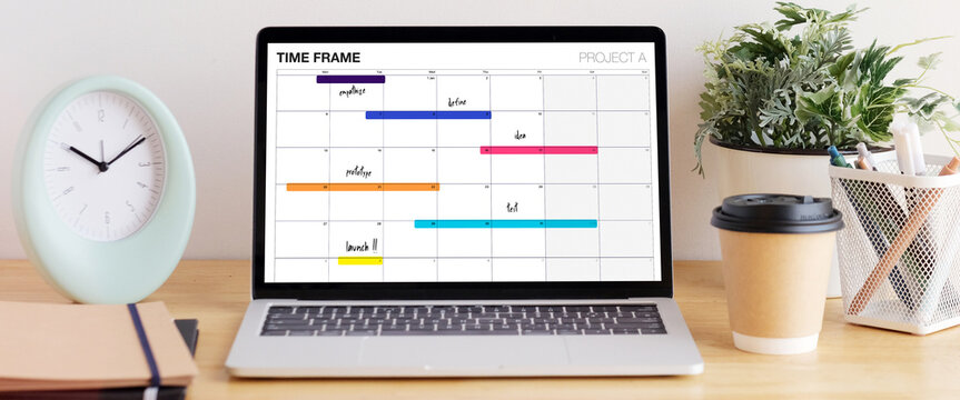 Laptop computer with timeline project schedule, work plan mangement, on table work with copy space