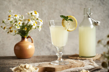 Fresh natural whey in a glass and bottle on a table