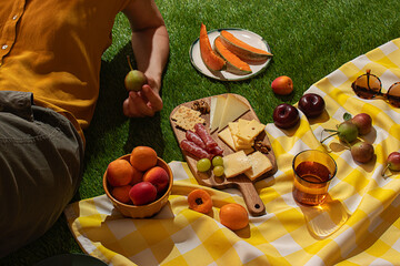Summer picnic with assorted fruits and cheeses on a blanket