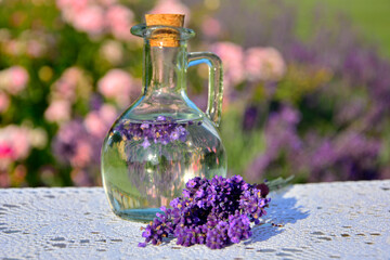woda lawendowa w szklanej butelce, woda aromatyzowana lawendą w butelce, woda lawendowa w szklanej butelce na stole, lavender water in a glass bottle, lavender water in a glass bottle on the table,  © kateej