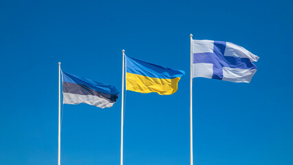 Estonia, Ukraine and Finland waving in wind and sunlight flags on the clear blue sky, alliance and meeting, cooperation of states. National symbol of freedom and independence