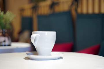 A white cup of coffee in a cafe. space for text