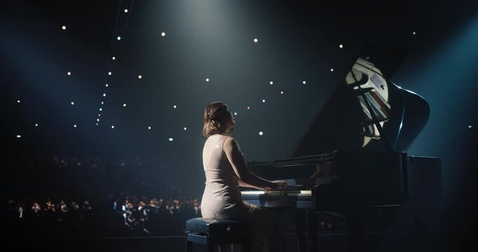 Classical Piano Concert: Under the Spotlight, Asian Female Pianist Delivering a Powerful Performance on the Grand Piano. Elegant Stage Setting Complements Her Passionate Playing. Footage From the Back