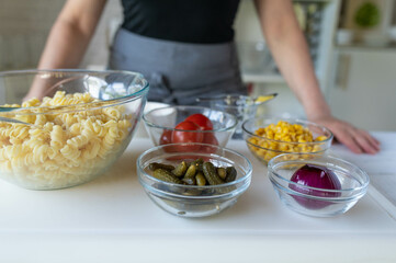 Woman preparing a fresh and healthy pasta salad. Vegetarian food
